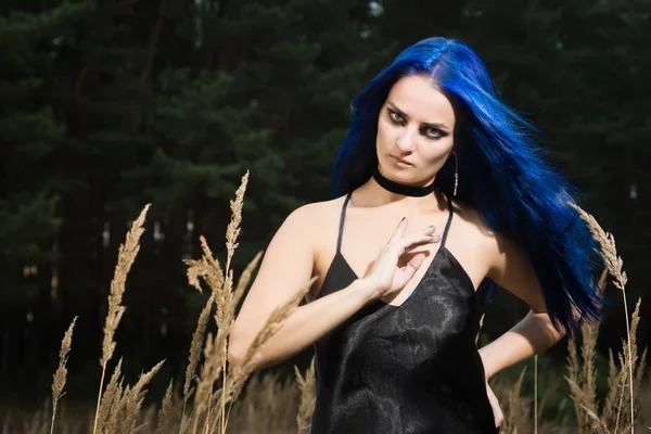 Mulher bonita com cabelo azul escuro vestido de vestido preto em th — Fotografia de Stock