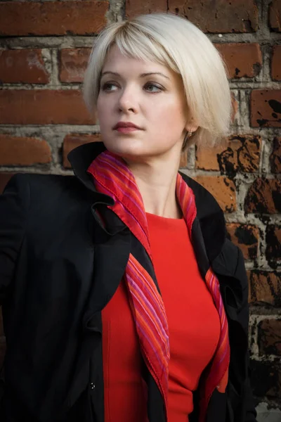 Noir film style woman in a black suit and red dress posing in a — Stock Photo, Image