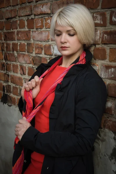 Noir film style woman in a black suit and red dress posing in a — Stock Photo, Image