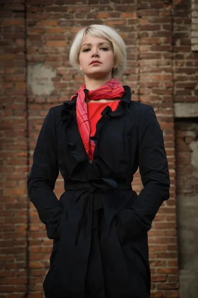 Noir film style woman in a black suit and red dress posing in a — Stock Photo, Image