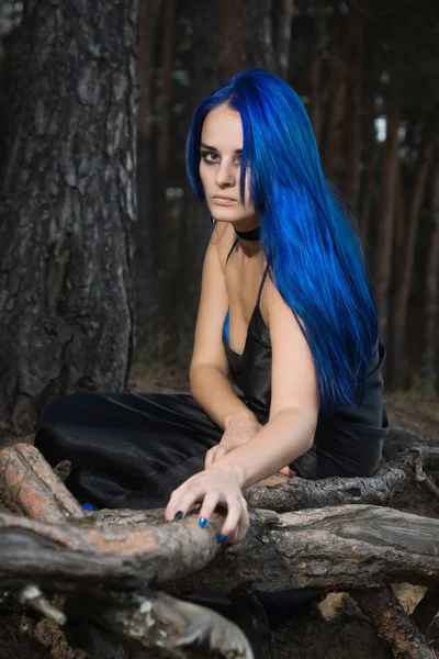 Piękna kobieta z ciemno niebieskie włosy, ubrany w czarny strój w th — Zdjęcie stockowe