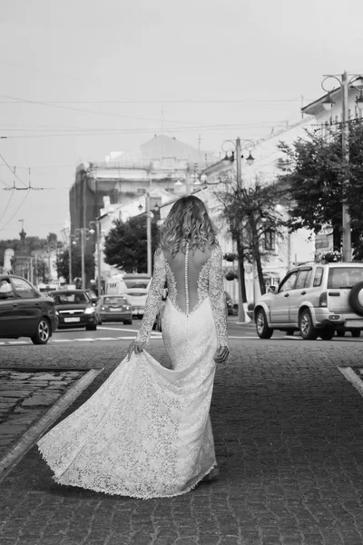 Hermosa novia en un vestido largo blanco en una calle de la ciudad — Foto de Stock