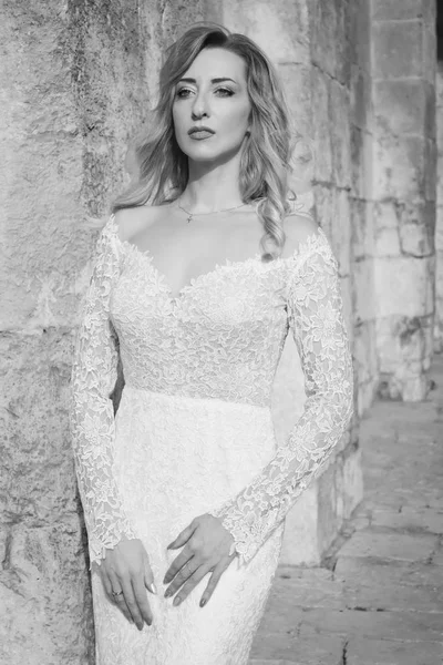 Mooie bruid in een witte lange jurk in een stad straat — Stockfoto