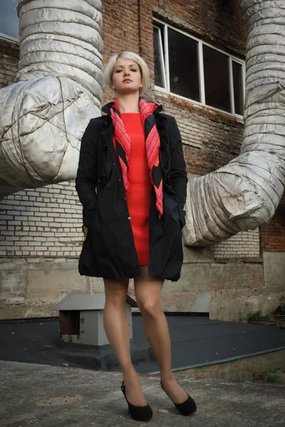 Noir film style woman in a black suit and red dress posing in a — Stock Photo, Image