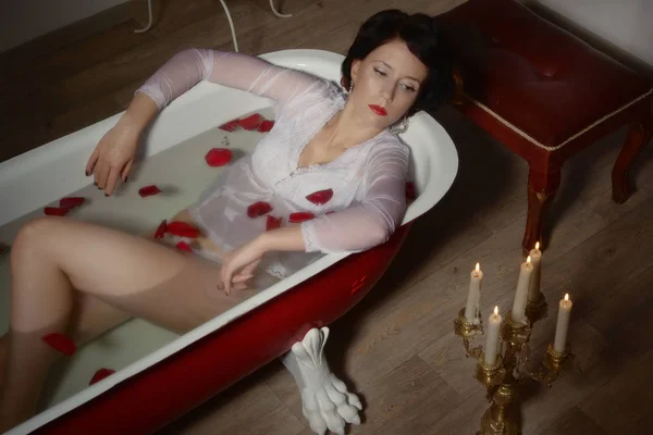Hermosa mujer sexy en baño vintage con pétalos de flores — Foto de Stock