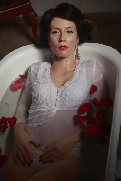Красивая сексуальная женщина в винтажной ванной комнате с лепестками цветов — стоковое фото