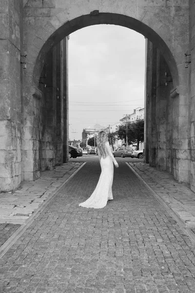 Hermosa novia en un vestido largo blanco en una calle de la ciudad — Foto de Stock