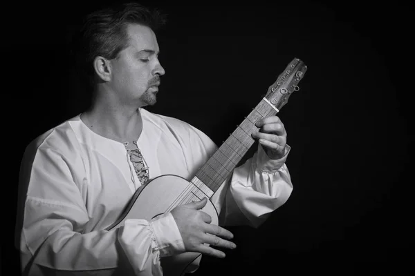 Человек играет на испанском инструменте эпохи Возрождения vihuela de mano — стоковое фото
