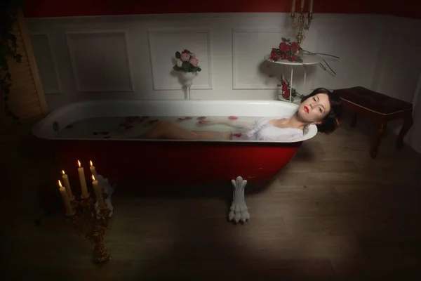 Belle femme sexy dans la salle de bain vintage avec des pétales de fleurs — Photo