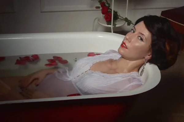 Bella donna sexy in bagno vintage con petali di fiori — Foto Stock