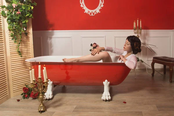 Belle femme sexy dans la salle de bain vintage avec des pétales de fleurs — Photo