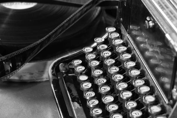 Old typewriter and a coil with a film. — Stock Photo, Image