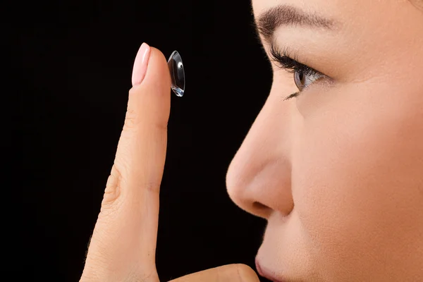 Крупный план женщины, надевающей контактные линзы — стоковое фото