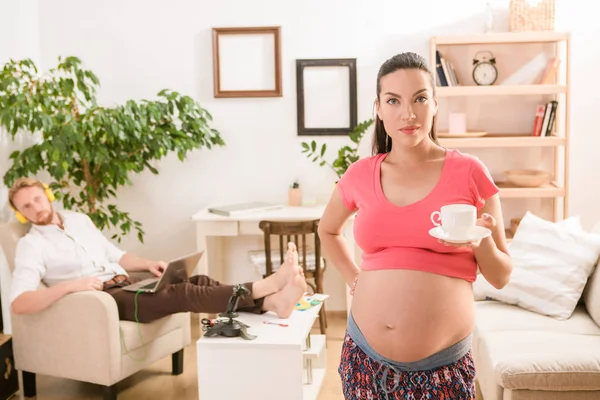 Gravid kvinna erbjuder kopp te eller kaffe hemma — Stockfoto