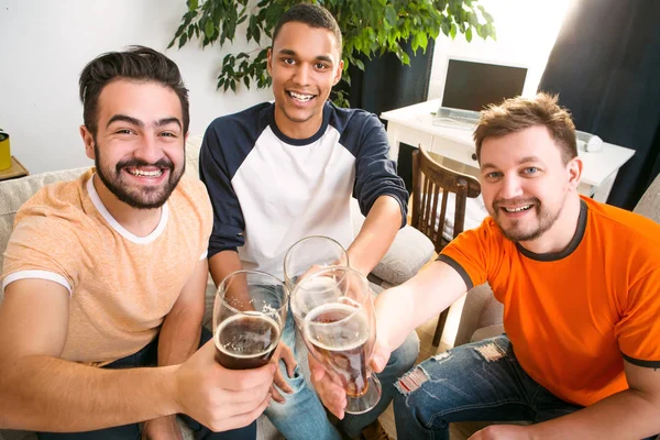 Amigos felizes bebendo cerveja em casa — Fotografia de Stock