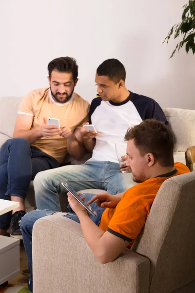 Vrienden met behulp van mobiele of slimme telefoons thuis — Stockfoto