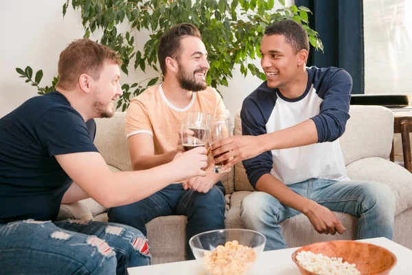 Amigos felizes bebendo cerveja em casa — Fotografia de Stock