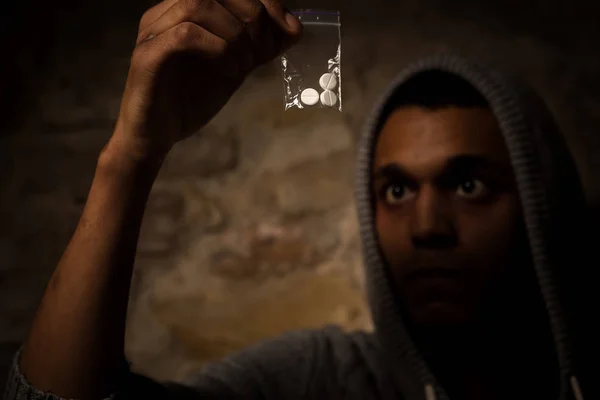 Drogenabhängiger Mann mit weißem Pulver vor sich. Mann schaut auf Drogen und zeigt es der Kamera. — Stockbild Drogen- und Betäubungsmittelkonzept — Stockfoto