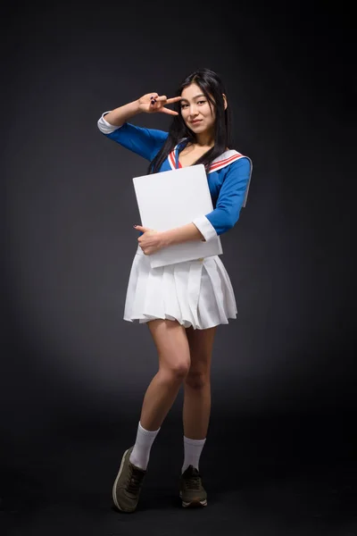 Femme asiatique posant avec affiche vierge en studio — Photo