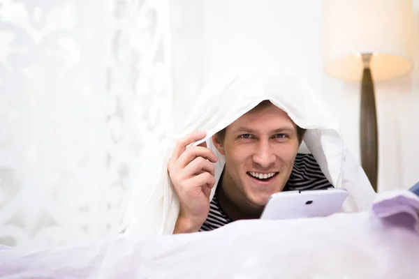 Mann mit Handy im Bett — Stockfoto