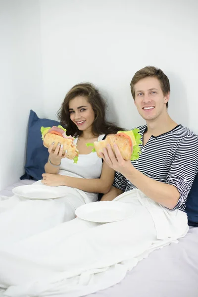 Пара їсть у ліжку — стокове фото