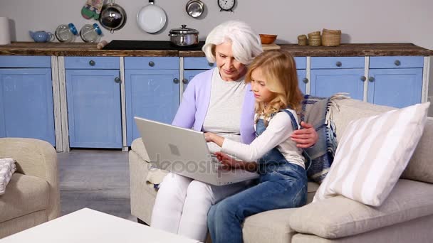 Abuela y niña utilizando el ordenador portátil — Vídeo de stock