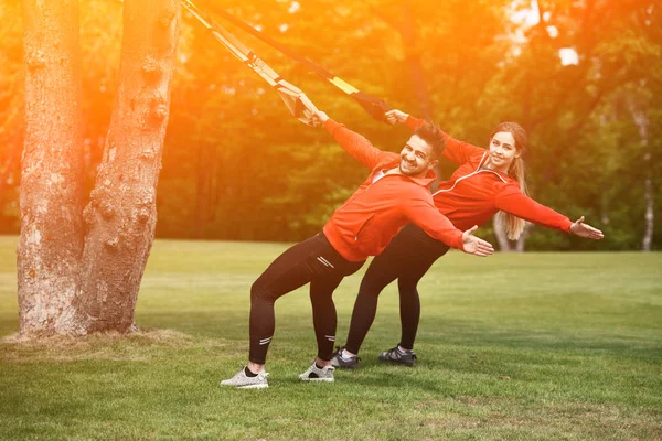 Sport man en vrouw in park met Trx training — Stockfoto
