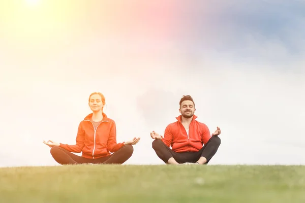 Sport férfi és nő, meditál, park — Stock Fotó