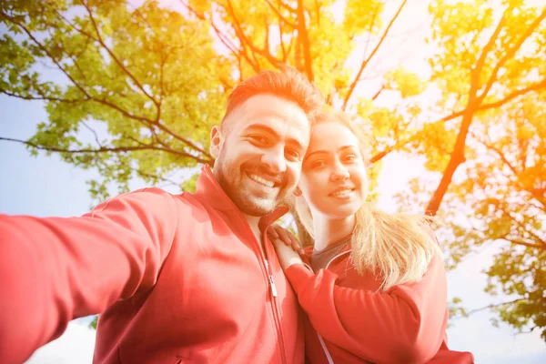 Sport man and woman making selfies in park — Stock Photo, Image