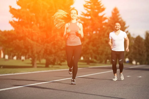 Sport man en vrouw joggen in het park — Stockfoto