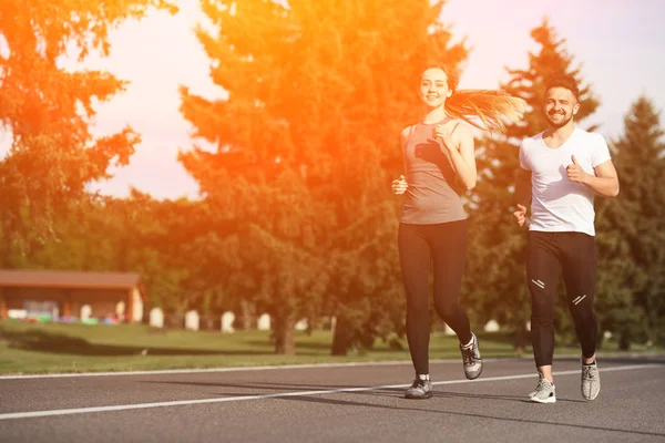 Sport man en vrouw joggen in het park — Stockfoto