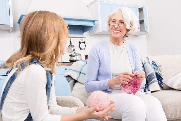 Grandmother and granddaughter knitting