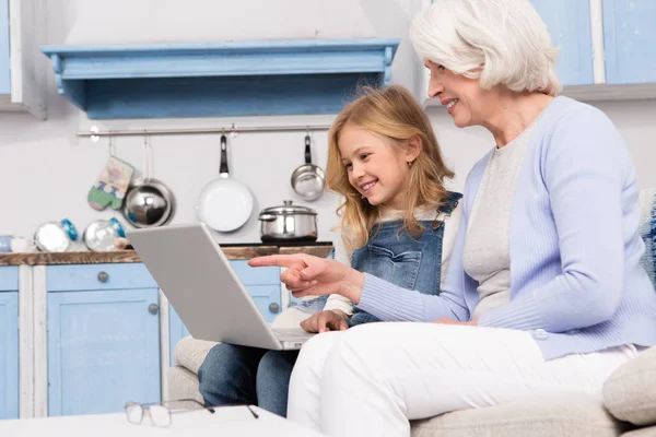 Oma en meisje met behulp van laptop — Stockfoto
