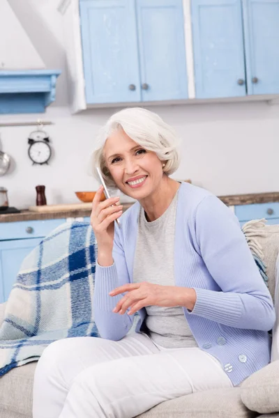 Mujer mayor usando teléfono móvil en casa — Foto de Stock