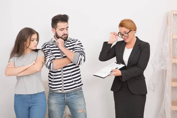 Agente propondo assinar aluguel cotntact para um casal hesitante . — Fotografia de Stock