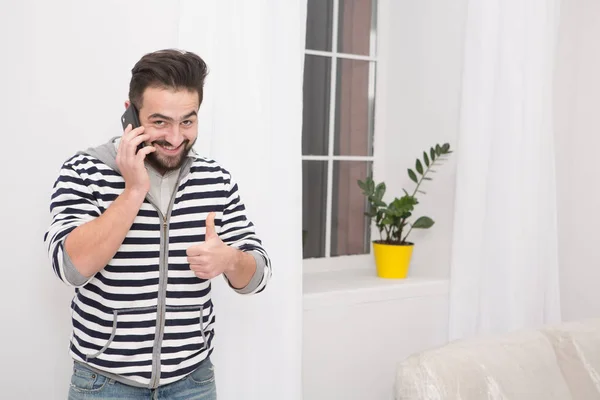 Glimlachende man praten over de telefoon thuis. — Stockfoto