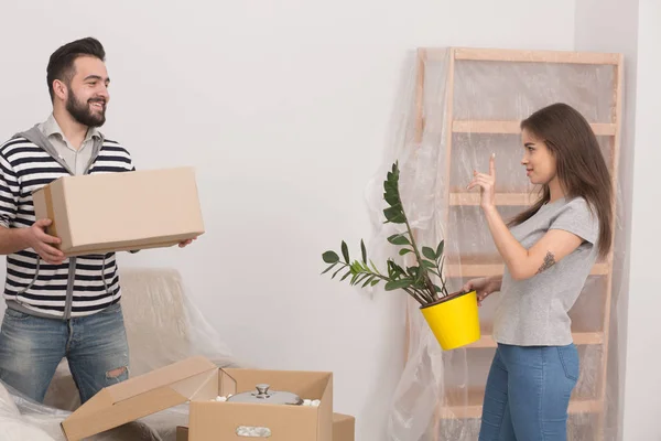 Молодая счастливая пара распаковывает коробки после переезда в новый дом . — стоковое фото