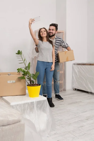 Мужчина и женщина в повседневной одежде стоят в новом доме после переезда, переходя к новой жизни . — стоковое фото