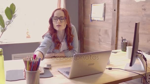 Freelance jonge vrouw werken bij laptop en het maken van notities op een stuk papier. — Stockvideo