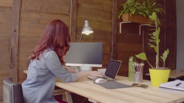 Вид збоку фрілансера жінка працює з ноутбуком . — стокове відео