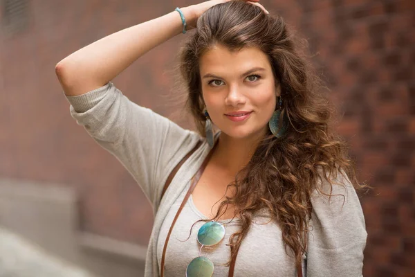 Meisje poseren voor de camera en het aanraken van haar reizen. — Stockfoto