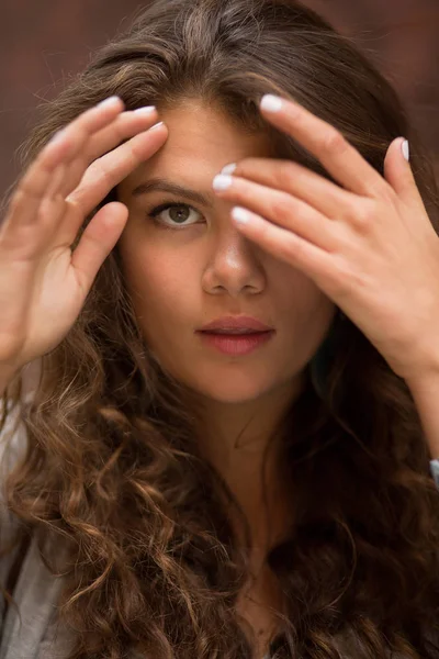 Nahaufnahme Porträt einer Frau mit langen braunen lockigen Haaren. — Stockfoto