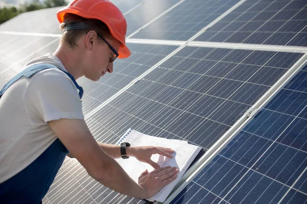 Employee working with drawings on solar energy station. — Stock Photo, Image