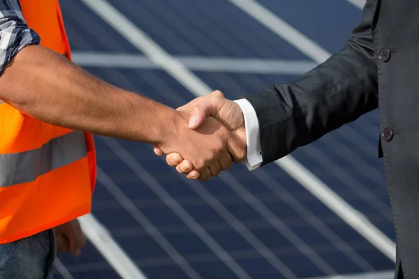 Foreman e empresário apertando as mãos na estação de energia solar . — Fotografia de Stock