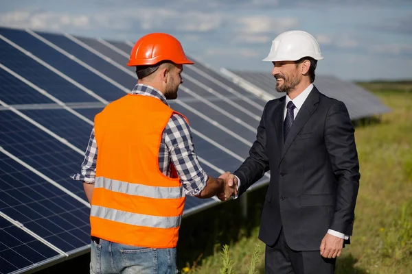 Empresario y capataz estrechando la mano en la estación de energía solar . — Foto de Stock