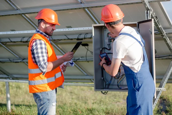 Worker and foreman cheking wires of solar panels. — Stock Photo, Image