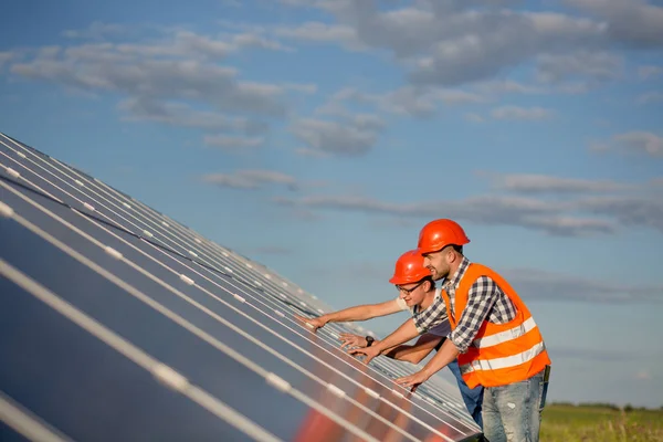 Ingenjörer som underhålla solpaneler i fältet. — Stockfoto