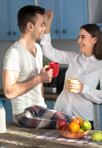 Ευτυχισμένος άνθρωπος και γυναίκα, που χαμογελά στην κουζίνα. — Φωτογραφία Αρχείου