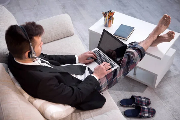 Man typing on laptop working on freelance at home.