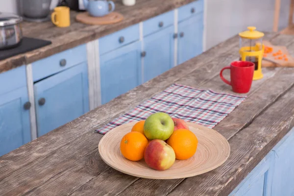 Vista sobre la mesa de madera en la cocina con fruta y tetera en ella . — Foto de Stock